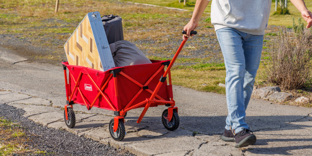 Coleman アウトドアワゴン レッド 2000021989でキャンプ用品を運ぶ様子